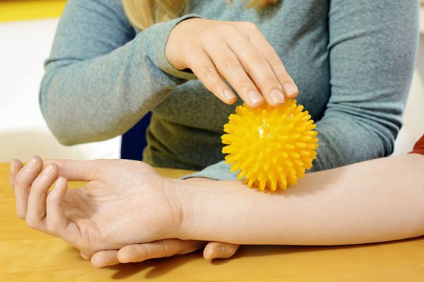 Ergotherapie mit Igelball auf Arm Ergotherapie mit Igelball auf Arm